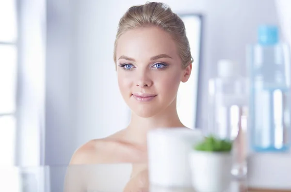 Giovane donna in accappatoio guardando nello specchio del bagno — Foto Stock