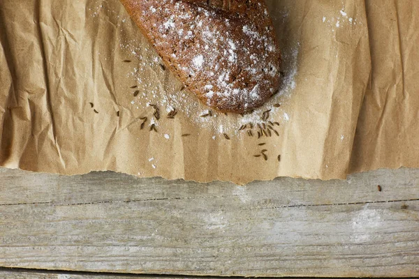 Panes de pan rústico recién horneados en bolsas de papel sobre fondo de madera oscura —  Fotos de Stock