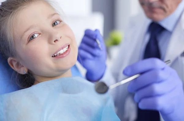 Niña sentada en el consultorio de dentistas — Foto de Stock