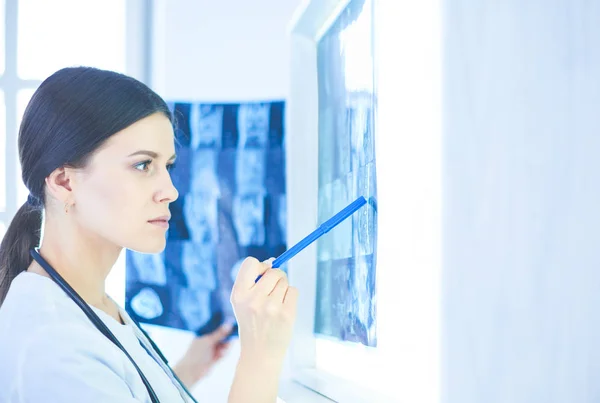 Jeune femme médecin souriante avec stéthoscope pointant vers la radiographie au cabinet des médecins — Photo