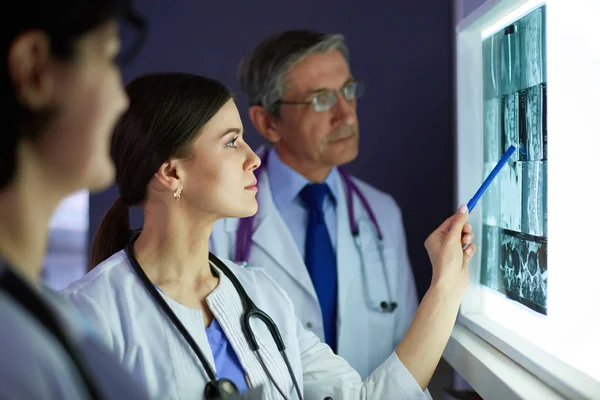 Groupe de médecins examinant les rayons X dans une clinique, en pensant à un diagnostic — Photo