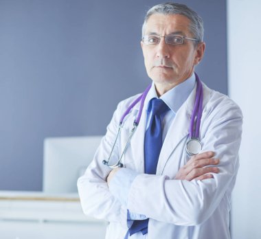 Parlak ofisinde gülümseyen bir doktorun portresi.