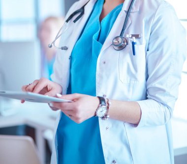 Hastane lobisinde tablet bilgisayar kullanan kadın doktor.