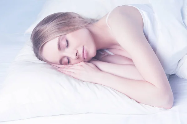 Yatakta gözleri kapalı yatan genç bir kadının fotoğrafı. — Stok fotoğraf