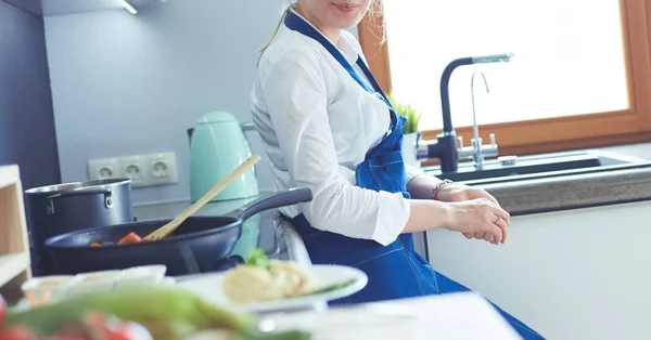 부엌에서 난로 옆에서 있는 젊은 여자 — 스톡 사진