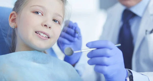 Niña sentada en el consultorio de dentistas — Foto de Stock