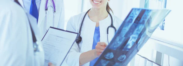 Uśmiechnięci lekarze omawiający diagnozę pacjentów patrzących na prześwietlenia w szpitalu — Zdjęcie stockowe