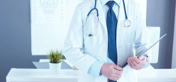 Man dokter schrijft notities op het klembord in het ziekenhuis — Stockfoto