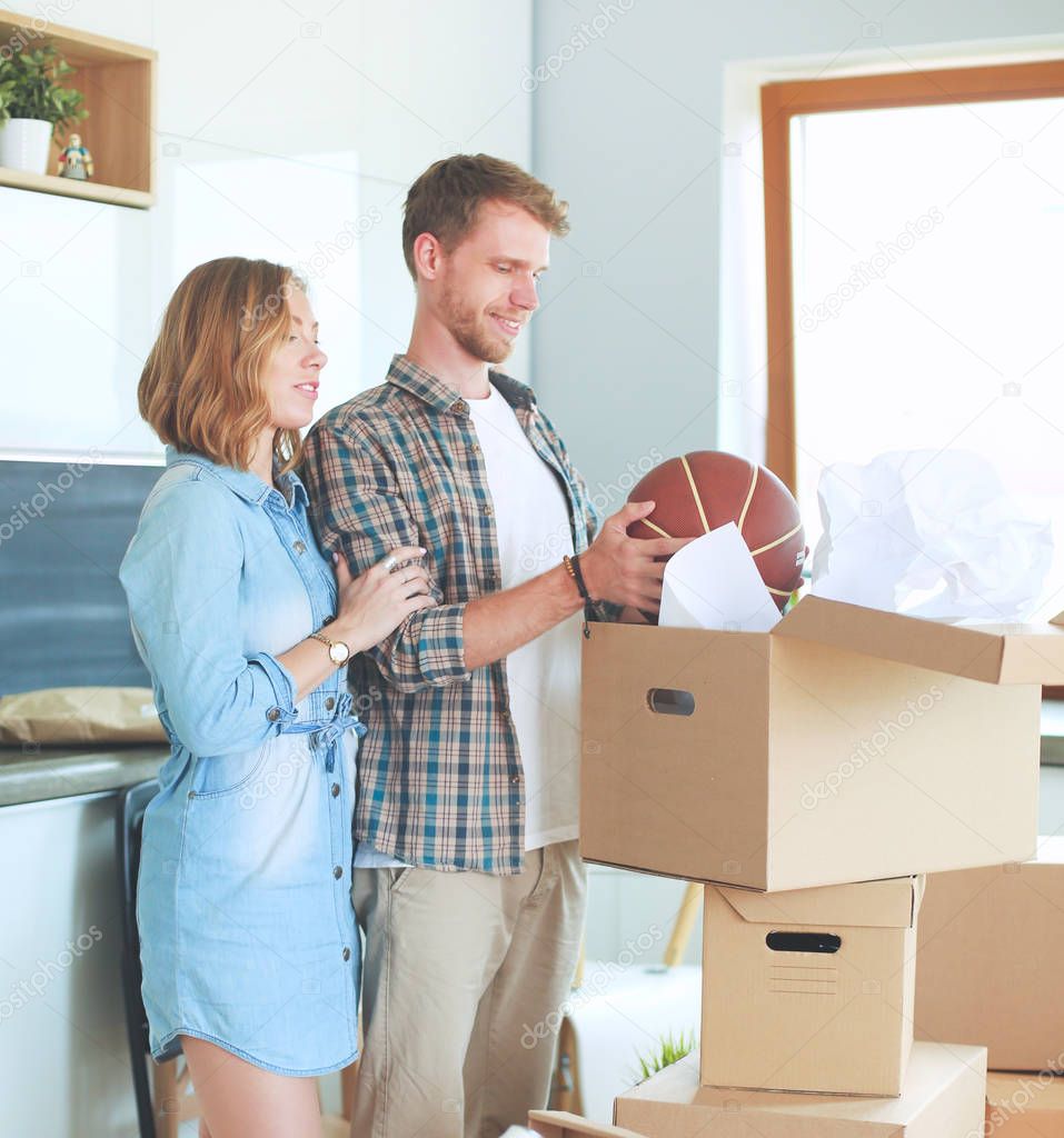 Couple unpacking cardboard boxes in their new home