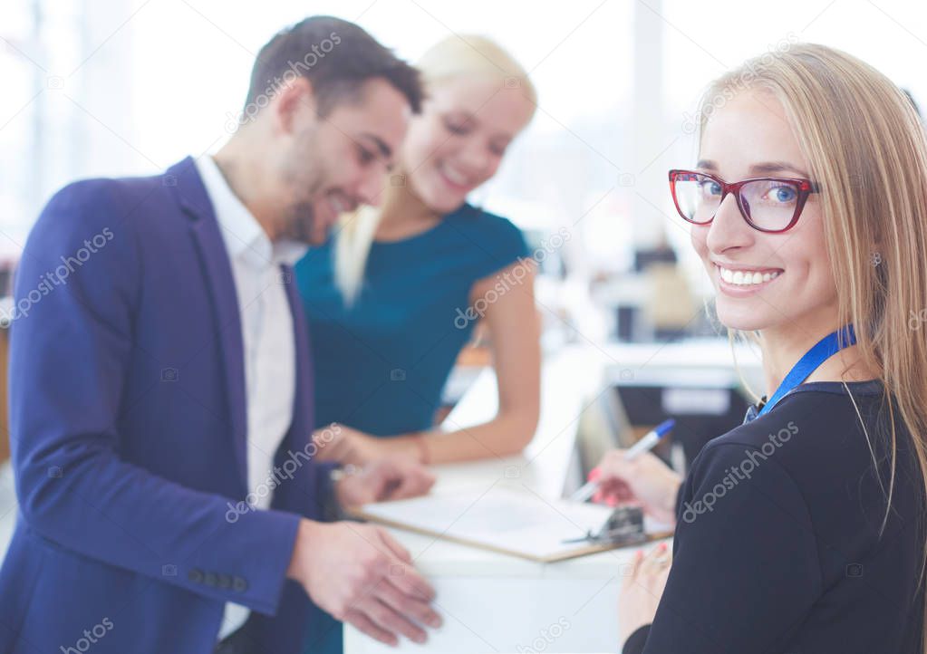 Sales situation in a car dealership, the young couple is signing the sales contract to get the new car