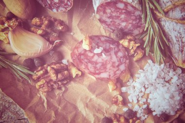 İtalyan salamı, deniz tuzu, biberiye, sarımsak ve fındık. Kırsal tarzda. Üst görünüm.