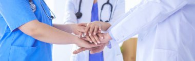 Bir grup doktor ellerini birleştiriyor. Yakın plan.