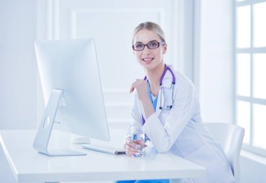 Modern bir hastanede masa başında çalışan bir kadın doktor.