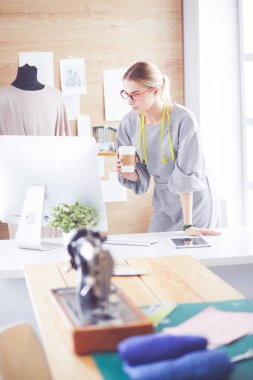 Moda tasarımcısı kadın dikiş makinesiyle dikiş dikiyor