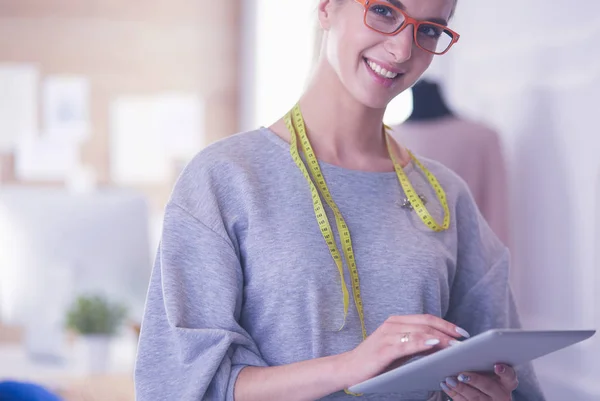 Mooie jonge vrouw werken op digitale tablet en glimlachen terwijl zitten op haar werkplek — Stockfoto