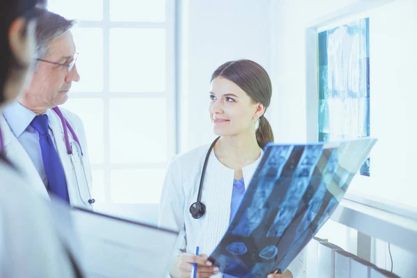 Lächelnde Ärzte diskutieren die Diagnose ihrer Patienten beim Röntgen im Krankenhaus — Stockfoto