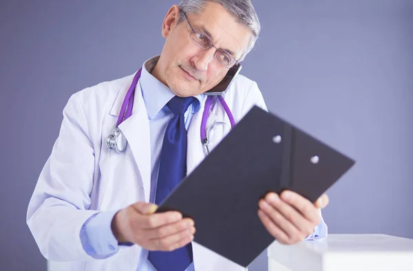 Male doctor writes notes on the clipboard in the hospital — Stock Photo, Image