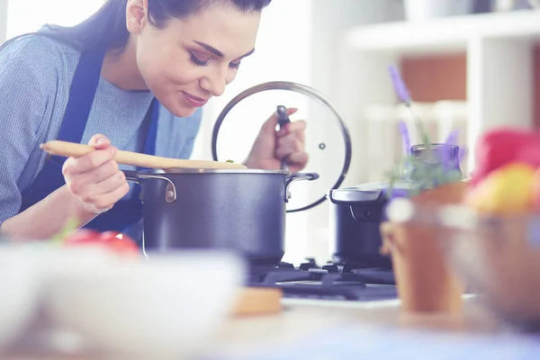 Cozinhar mulher na cozinha com colher de madeira — Fotografia de Stock