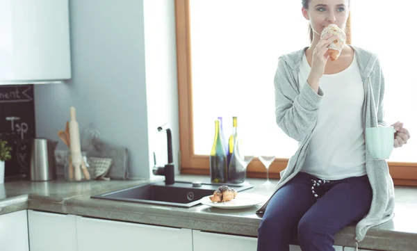 Vacker ung kvinna med hjälp av en digital tablett i köket. — Stockfoto