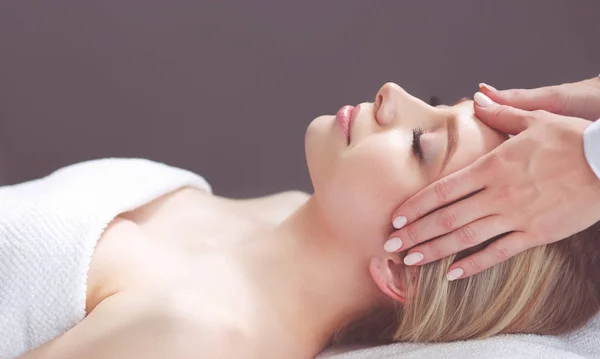 Mujer joven acostada en una mesa de masaje, relajándose con los ojos cerrados. Una mujer. Salón de spa — Foto de Stock