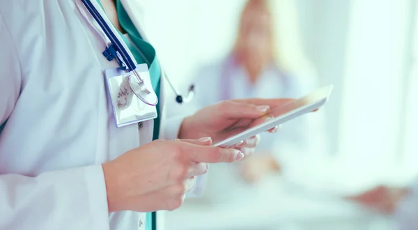 Retrato de uma jovem médica, com aipads na mão, em um consultório médico — Fotografia de Stock