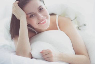 Güzel bir kadın yatağında uzanıyor..