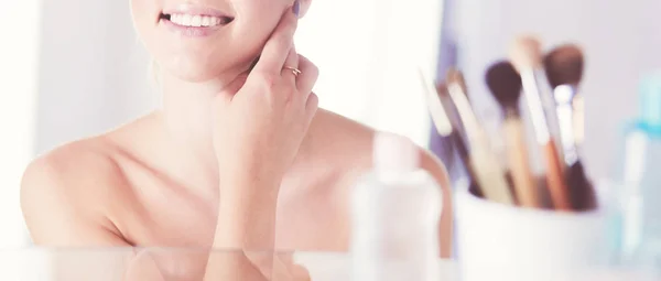 Young woman in bathrobe looking in bathroom mirror — Stock Photo, Image