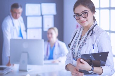Kadın doktor hastanede steteskopla dikiliyor.