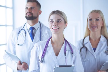 Gülümseyen doktorlar çalışırken bir arada duruyorlar.