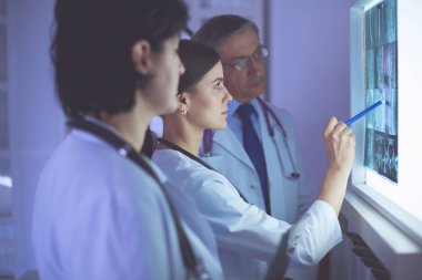 Bir grup doktor hastanede röntgenleri inceliyor.