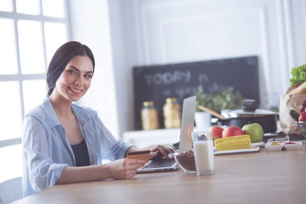 Online vásárlás a tábla és a hitelkártya konyhában mosolygó nő — Stock Fotó
