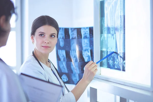 Due medici sorridenti che puntano i raggi X in una sala di consulenza ospedaliera — Foto Stock