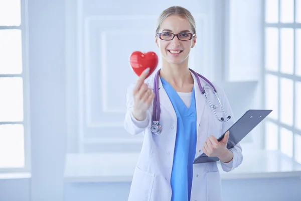 Female doctor with the stethoscope holding heart — Stock Photo, Image