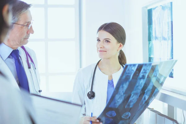 Lächelnde Ärzte diskutieren die Diagnose ihrer Patienten beim Röntgen im Krankenhaus — Stockfoto