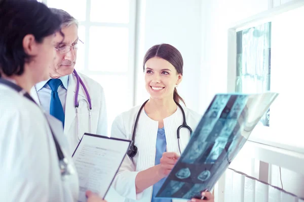 Lächelnde Ärzte diskutieren die Diagnose ihrer Patienten beim Röntgen im Krankenhaus — Stockfoto