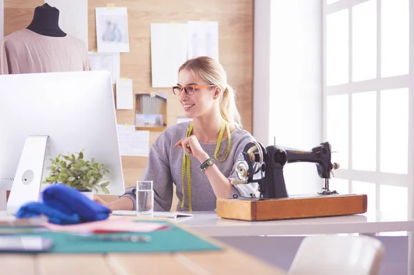 Schönes junges Mädchen in einer Fabrik mit einer Nähmaschine am Tisch — Stockfoto