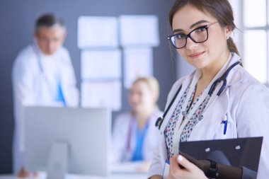 Kadın doktor hastanede steteskopla dikiliyor.