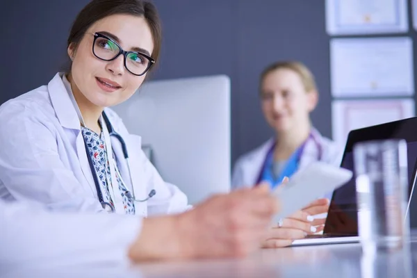 Seriöses Ärzteteam mit Laptop in hellem Büro — Stockfoto