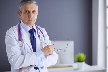 Parlak ofisinde gülümseyen bir doktorun portresi.