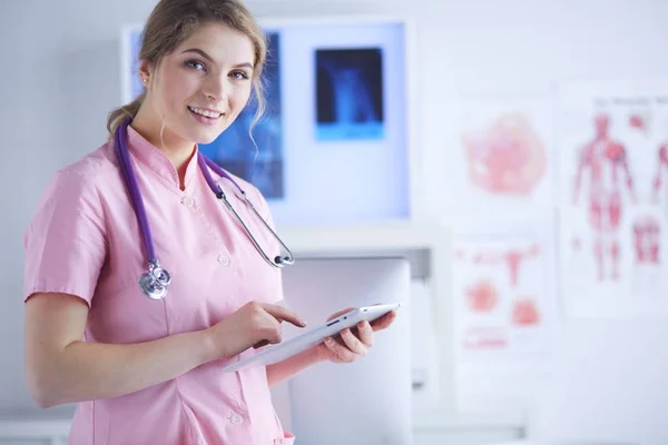 Mooie vrouwelijke gezondheidswerker met behulp van tablet computer in het ziekenhuis — Stockfoto