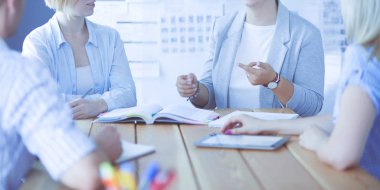 Masada kitaplarla çalışan gençler. Güzel kadınlar ve erkekler birlikte çalışıyor.