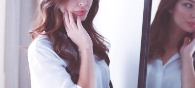 Genç kadın kendini yansıma evde aynaya bakıyorum. Genç kadın.