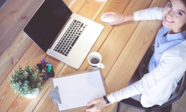 Masasında oturan ve elinde bir fincan kahveyle rahatlamış genç bir kadının portresi. İş kadını. İşyeri