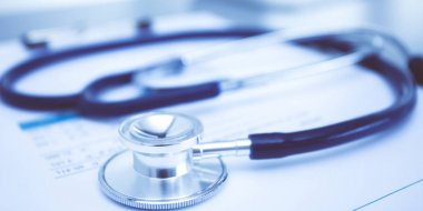 Tıbbi ekipman: Beyaz arka planda mavi steteskop ve tablet. Tıbbi ekipman