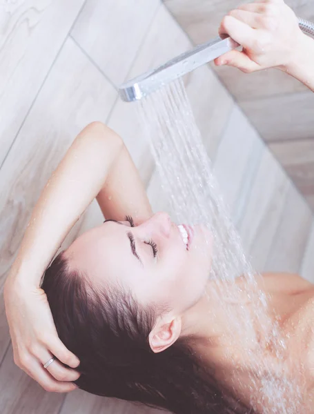 Joven mujer hermosa bajo la ducha en el baño . —  Fotos de Stock