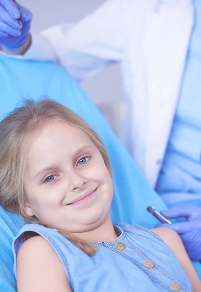 Niña sentada en el consultorio de dentistas. — Foto de Stock