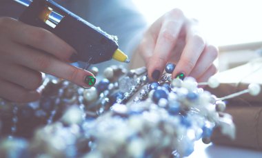 Masada oturan Noel süslemeleri aksesuarları hazırlama kadın.