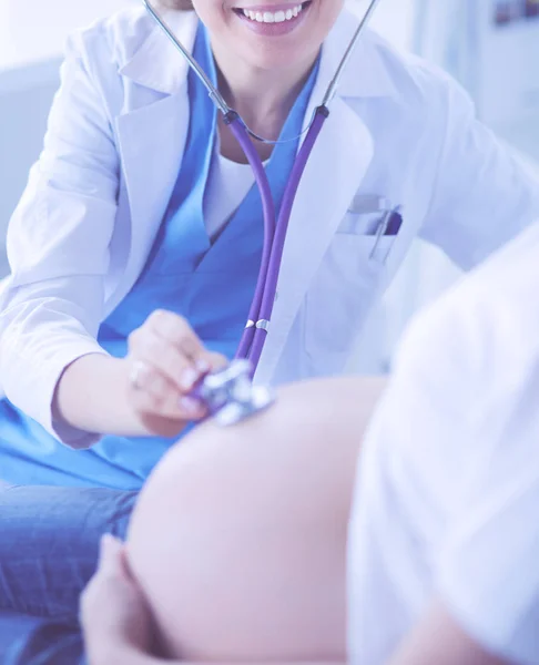 Doctora joven examinando a una mujer embarazada en la clínica. — Foto de Stock