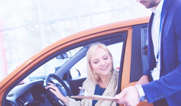 美しい若い女性は、新しい車に座っている間、キーを取得し、笑顔を取得しています — ストック写真
