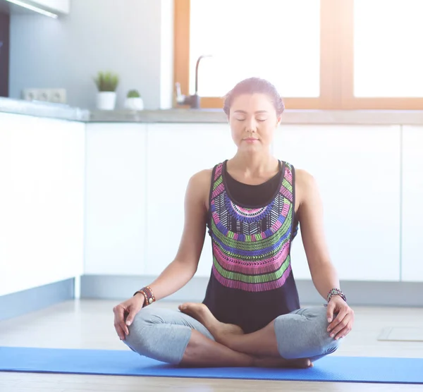 Mujer joven haciendo yoga en casa en la posición de loto. Yoga. Una mujer. Estilo de vida — Foto de Stock